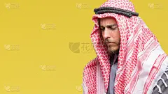 年轻英俊的阿拉伯男子与长头发戴keffiyeh在孤立的背景与手胃，因为恶心，痛苦的疾病感觉不舒服。疼