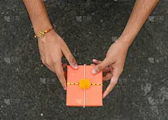 Raksha Bandhan，红色背景上美丽的Rakhi的印度节日。一种传统的印度腕带，象征着兄弟姐