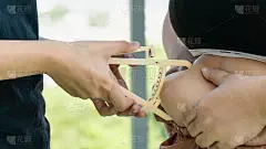 手持卡尺测量胖胖女人腹部的脂肪厚度