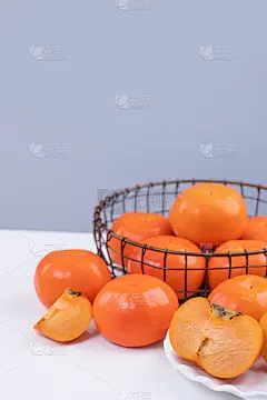 新鲜漂亮的切好的甜柿子卡吉孤立在白色的厨房桌子上，以灰蓝色为背景，中国农历新年设计理念，近距离。