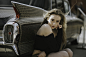 woman sitting beside car
