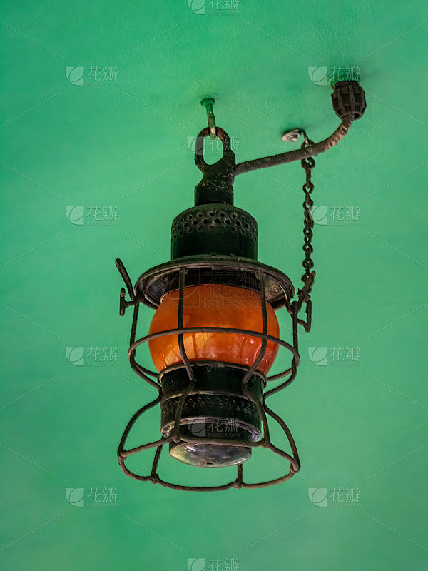 老式橙色煤气灯悬挂在绿色天花板上