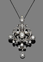 A diamond brooch/pendant, circa 1890  The openwork cartouche of scrolling floral design, set throughout with old brilliant, single and rose-cut diamonds, mounted in silver and gold, to a trace-link chain, old brilliant and single-cut diamonds approx. 2.00