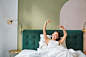 Portrait of smiling happy asian girl wakes up feeling enthusiastic stretches her hands up enjoys goo