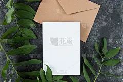 现场邀请布局与树叶。空白贺卡，一个信封和一张白纸在黑暗的背景。女性仍然生活。平躺，俯视图