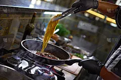 厨师在平底锅中加入西红柿和牡蛎炒意面。海鲜意大利面烹饪的过程。