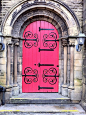 The poppy colour, arched top and the black scrollwork make this an enchanting entry...