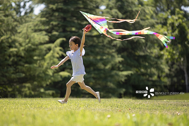 快乐的小女孩在草地上放风筝图片素材