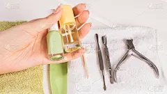 修指甲。女人手里拿着指甲油和角质层油。修指甲的工具。家居美甲、SPA、美容。长自然指甲。美容院。
