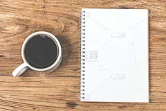 木桌上放着空白的名片和一杯咖啡。企业文具品牌模拟。