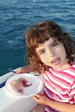 姑娘带着两只海蜇在白色的盘子里船蓝色的海