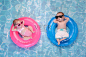 婴儿双胞胎男孩和女孩浮游在游泳圈