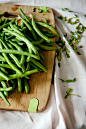 green peas on top of brown wooden chopping board