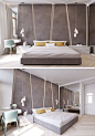 The grey upholstered headboard in this modern bedroom almost takes up the entire wall. The angular panels have hidden lighting between them giving the bedroom a soft glow.: 