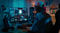 职业玩家在他强大的个人电脑上用彩色霓虹灯玩第一人称Shooter在线视频游戏。年轻人戴着帽子。客厅里点亮了暖和的灯。晚上好。