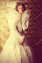 美丽的时装模特高雅的白色礼服和优雅的帽子。复古的风格。艺术项目