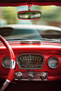 realistic detail photo of a 1950s red vintage car dashboard