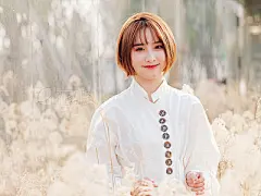 Beautiful young brunette woman in white shirt smiling at camera in sunny day. Outdoor fashion portrait of glamour Chinese cheerful stylish girl, emotions, people, beauty and lifestyle concept.Beautiful young brunette woman in white shirt smiling at camera
