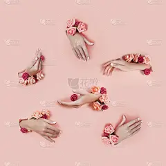 用粉红色的纸作背景，在手上插着假花。上交各种姿势，为你拼贴图案布局。化妆品手部护肤，保湿祛皱