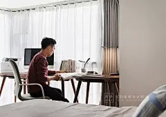 沿窗放置的书桌椅构成主卧空间里的工作区，三张简单的木桌拼合而成的工作台，足以供夫妻二人同时使用。