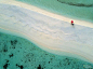 在马尔代夫南阿里环礁小岛的沙洲上，有一顶红色的遮阳伞，与碧蓝的海水相得益彰。