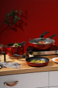 red and black cooking pot on brown wooden table