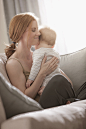 Caucasian mother sitting on sofa holding son by Gable Denims on 500px