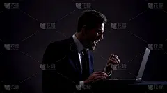 年轻的交易员在笔记本电脑上工作，做一笔成功的交易，表现出肯定的姿态