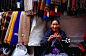 Tibetan woman knitting at shawl stall on Jogibara Road.