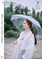 打着伞穿着雨衣出去游玩的少女