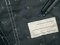 贴在工作服上写上主人的名字。一个干净的名称补丁的特写。姓名标签