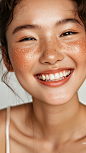 An Asian woman freckles on their Cheeks,laugh heartily,The product is placed on the sides of the cheeks,Freckles,positively,healthy skin tone, A white background, unpolished