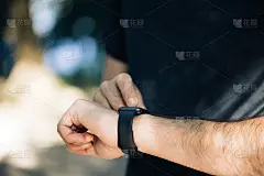 近距离观察男性的手与现代智能手表小配件外的黑色触摸屏。检查网上通知。测量距离，心率。医疗保健