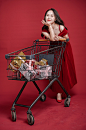 红裙女性推购物车网络新年购物摄影图