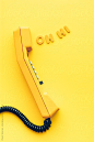 Old yellow phone with greeting coming out from earpiece by Pixel Stories for Stocksy United