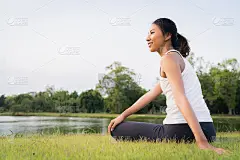 年轻的亚洲女性瑜伽户外保持冷静和冥想，同时练习瑜伽探索内心的和平。瑜伽在公园的湖边对健康有好处。运动