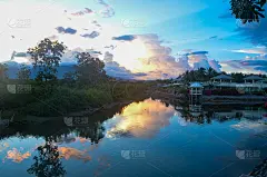 色彩缤纷的热带滨海水景景观与灌木、树木、蓝天、溪水倒影。