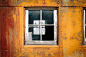 The close-up view of a glass window of a rusty and old metal building in western pacific railroad museum.