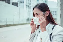 亚洲女性要去工作。她戴着N95口罩。防止PM2.5粉尘和雾霾