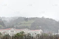 西班牙巴斯克地区毕尔巴鄂的新古典主义Deusto大学，在一个阴雨连绵的冬天，在一座绿色和雾蒙蒙的小山