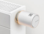 a white wall mounted heater with thermostaer on it's side