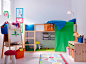 A colorful children’s room with a loft bed in solid pine with space underneath for drawing and reading. Combined with low storage in solid pine with plastic boxes in pink, green and orange.