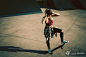 Young woman standing on a skateboard and listening to music in s