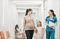 Nurse talking to mother and daughter in hospital corridor by Caia Images on 500px