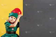 穿着精灵服装的小女孩。在黑色背景的子元素附近有一个用于文本、复制的空间。节日的照片。