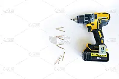 特写无名称黑黄电动无绳螺丝刀，不新，数量自攻螺钉黄色金属列为模板为子弹表，白色木桌为背景。本空间