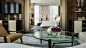 Four Seasons Deluxe Executive Suite living room with round glass coffee table, door to bedroom