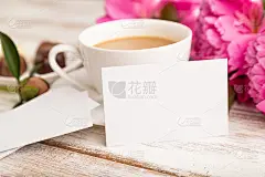 白色名片与粉红色牡丹花和一杯咖啡在白色木制背景。侧视图，复制空间，静物。早餐，早晨，春天的概念。