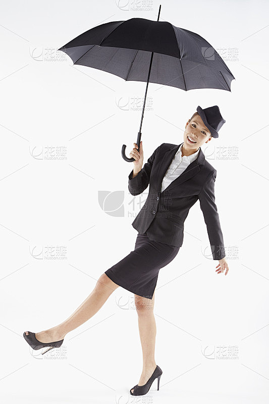 快乐的女商人拿着伞摆姿势