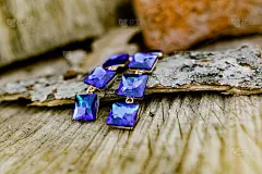 节日专用的人造珠宝，长耳环，上面镶有大的方形蓝宝石和深蓝色的手镯。